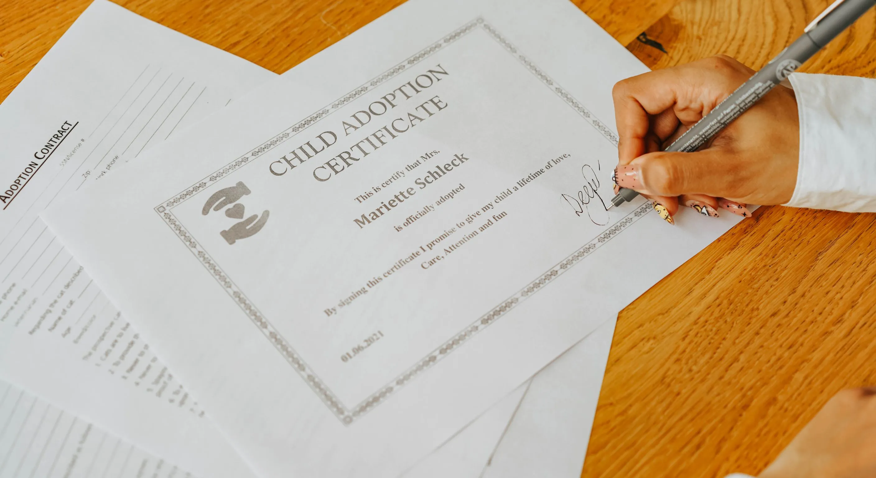 A hand signs a formal insurance certificate document with a pen on a wooden desk.